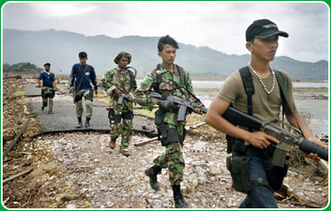 Free Aceh Movement (GAM) fighters patrol an area flattened by the tsunami.